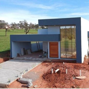 Modern unfinished house with glass facade and blue accents.