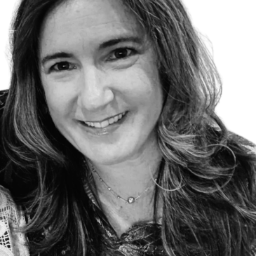 Black and white portrait of a smiling woman with long hair.