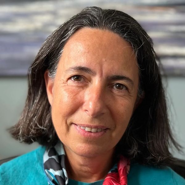 Portrait of a middle-aged woman with dark hair and a colorful scarf.