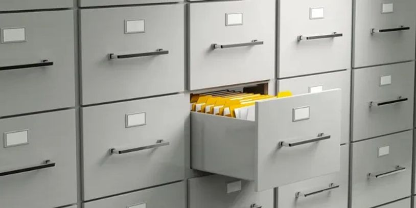 Open filing cabinet drawer revealing organized yellow folders.