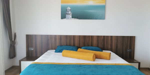 Modern bedroom with a wooden headboard and vibrant blue and yellow bedding.