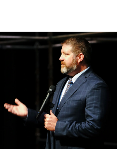 Dr. Lane Freeman delivers a keynote presentation in a large auditorium. 