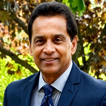 Professional man smiling in a suit outdoors.