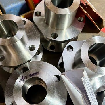 Shiny metal flanges with bolt holes stacked together.