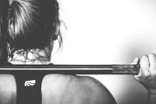 Woman with barbell in personal training session 