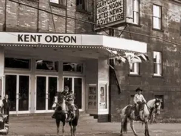Two people on horseback in front of Kent Odeon cinema.
