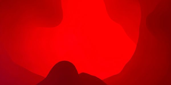 Abstract red shapes with a dark silhouette in the foreground.