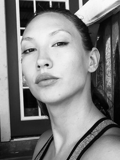 Black and white close-up portrait of a woman with a confident expression.