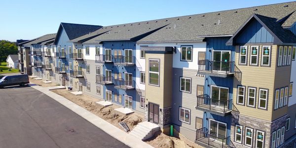 Newly constructed modern apartment building with balconies and large windows.