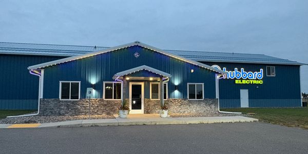Exterior view of Hubbard Electric building at dusk with illuminated signage.