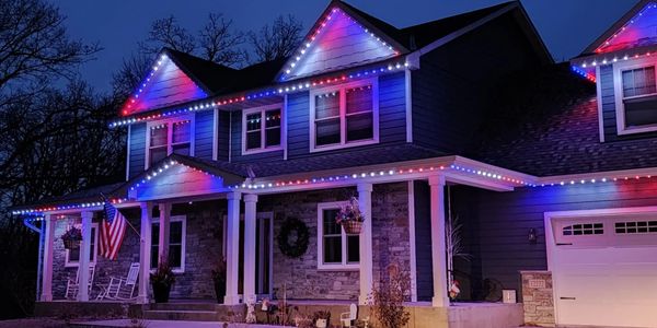 A house decorated with red, white, and blue lights at night.