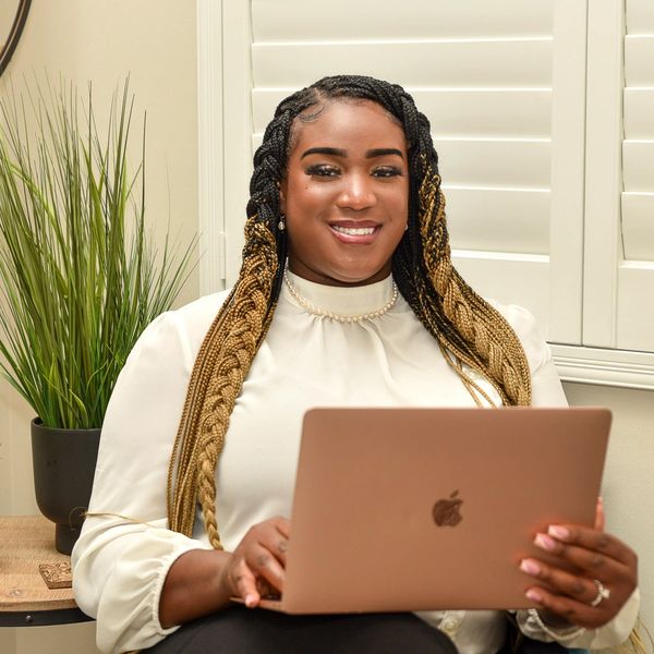 Latreanna White an African American Therapist sitting with a computer. Black therapist. 