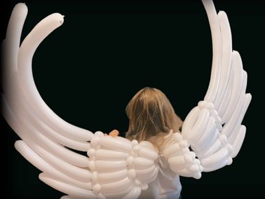 White 260q balloons twisted into shape of angel wings worn by small child