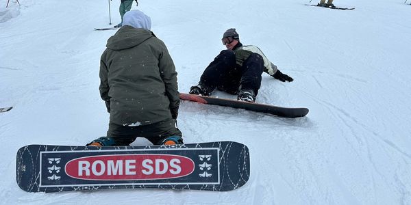 Two snowboarders on a snowy slope.
