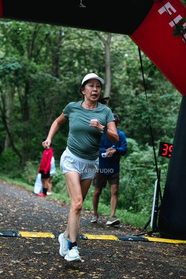 Woman sprinting in a forest race.