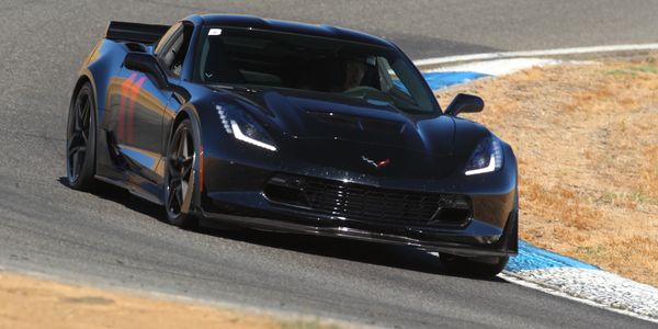 A sleek black sports car taking a turn on a race track.