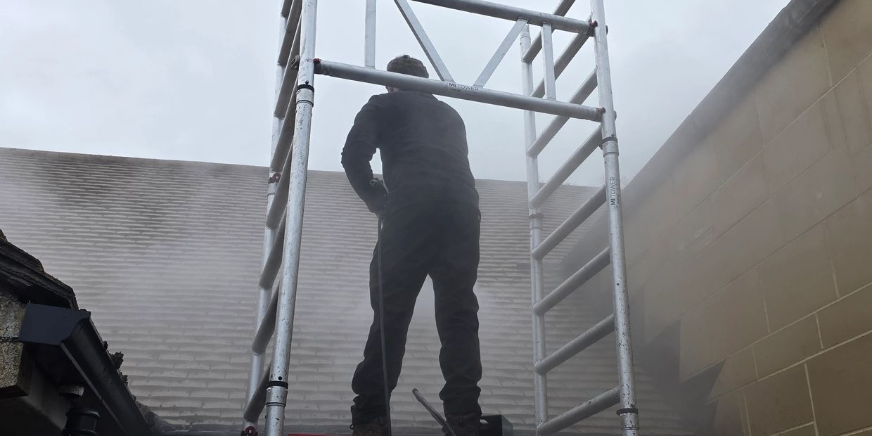 Roof cleaning using steam on mi tower scaffolding