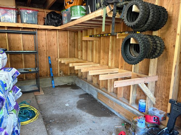Wooden shelves under construction in a garage or shed.