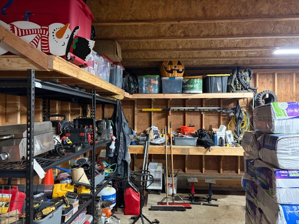 Organized garage with tools, shelves, and seasonal decorations.