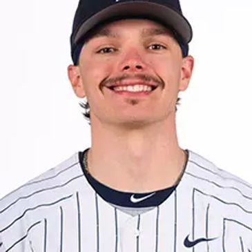 Smiling baseball player in pinstripe jersey and cap.