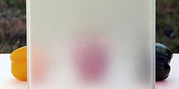 Frosted glass panel with blurred colorful objects behind it.
