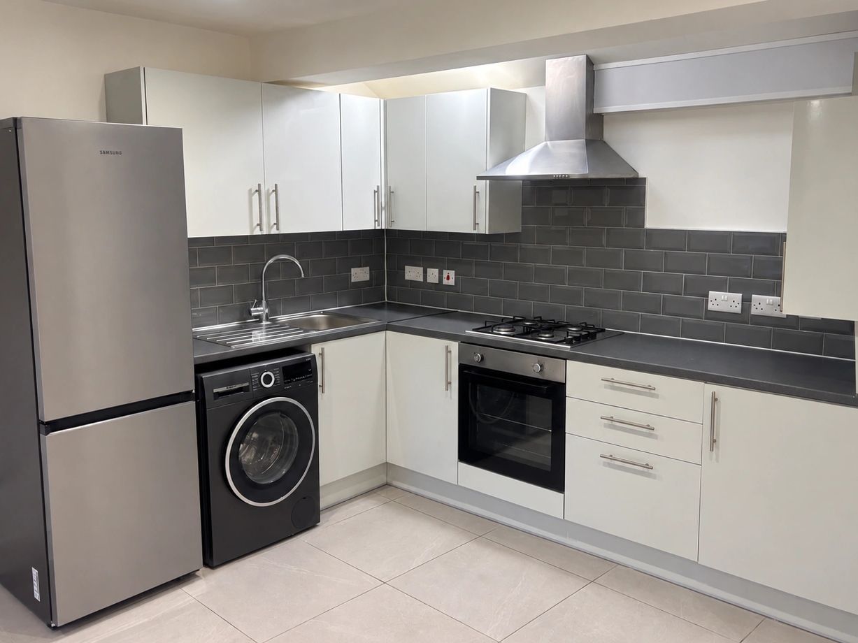 Modern kitchen with stainless steel appliances and white cabinets.