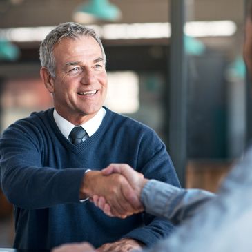 Smiling businessman shaking hands during a meeting.