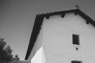 Black and white photo of a rustic building with a cross on top.