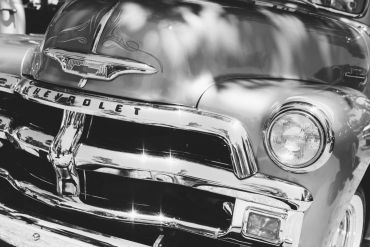 Close-up of a vintage Chevrolet car front in black and white.