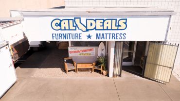 Entrance of Cal Deals Furniture and Mattress store with outdoor furniture display.