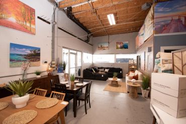 Spacious, well-lit living and dining area with modern decor and high ceilings.