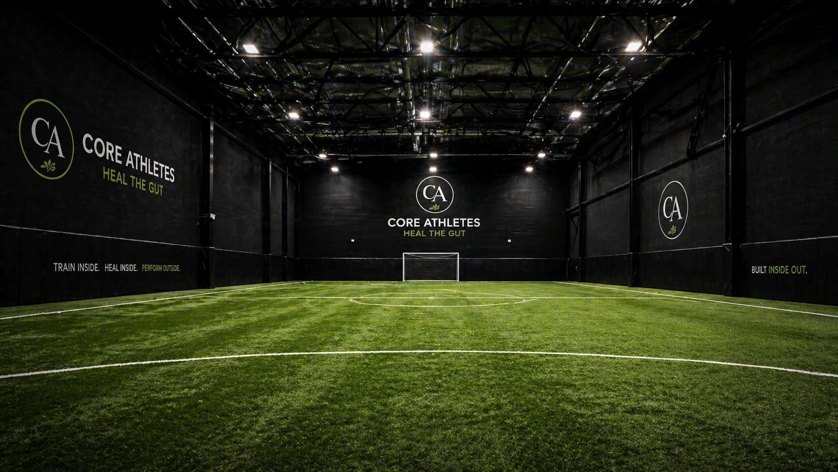 Indoor soccer field with CORE ATHLETES branding and motivational phrases on black walls.