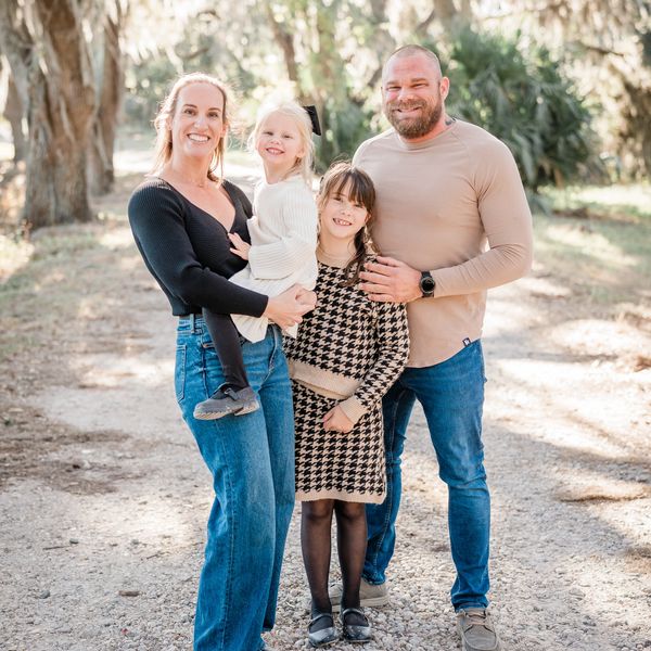 Beautiful family taking a picture under miss filled oak trees.