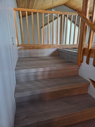 Wooden staircase with modern steps and railing.