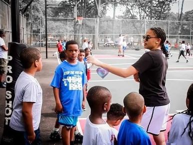 Coach instructs kids at basketball court.