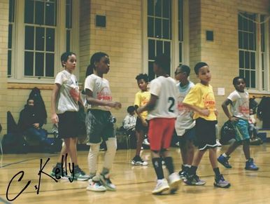 Kids playing basketball indoors.