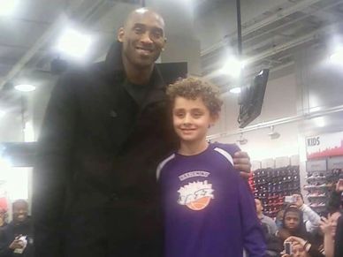 Man posing with a boy in a sports store.