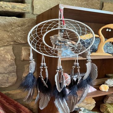 Decorative dreamcatcher with feathers hanging indoors.