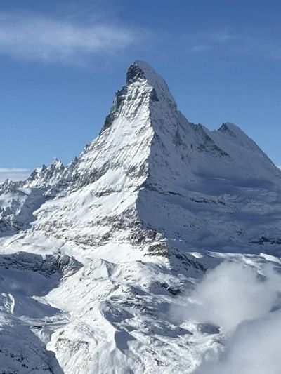 Snow-covered mountain peak under a clear blue sky.