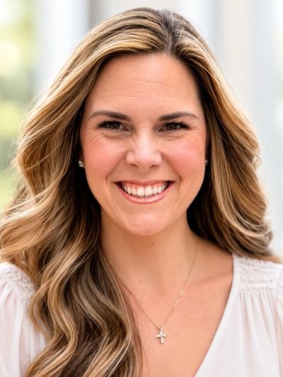 Smiling woman with long wavy hair.