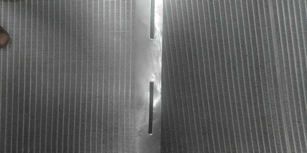 Close-up of a metallic mesh with a vertical metal strip in the center.