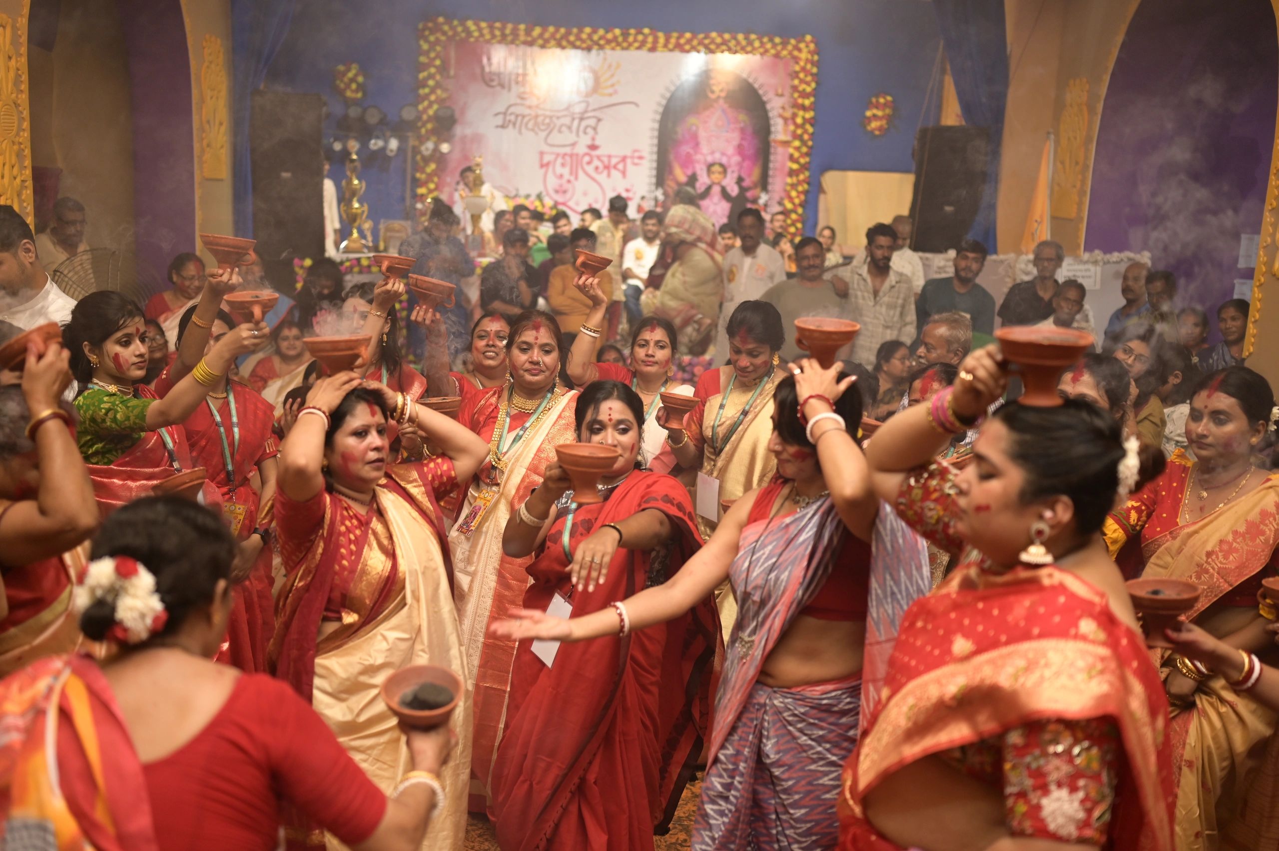 Women performing a traditional ritual with lamps.