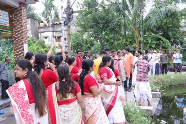 Group of people in traditional attire celebrating outdoors.