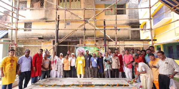 Group of people posing in front of a decorated area with scaffolding.