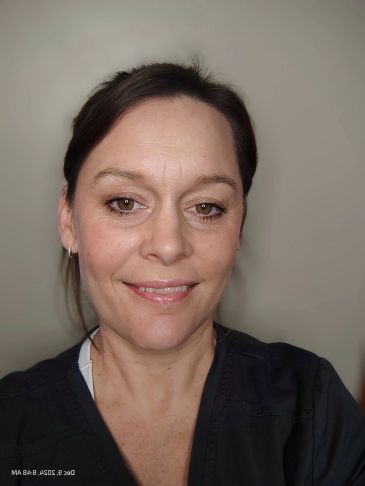 Smiling woman with dark hair in black top.