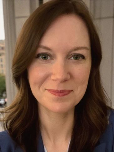 Woman with brown hair smiling gently.