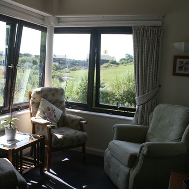 A light and welcoming room with a beautiful view and comfortable seating 