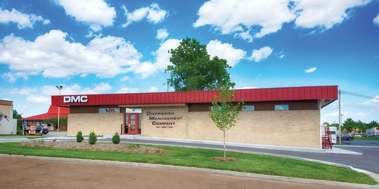 Picture of the exterior of a brick building with parking lot