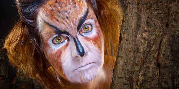 Person with detailed animal-themed face paint resembling a wild cat.