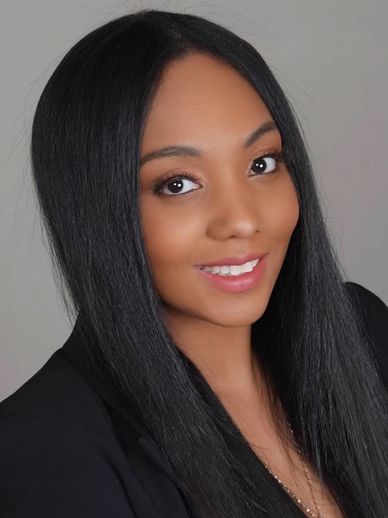 Smiling woman with long straight black hair in a black blazer.
